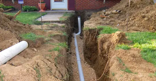 Dugged sewer line in front of a house